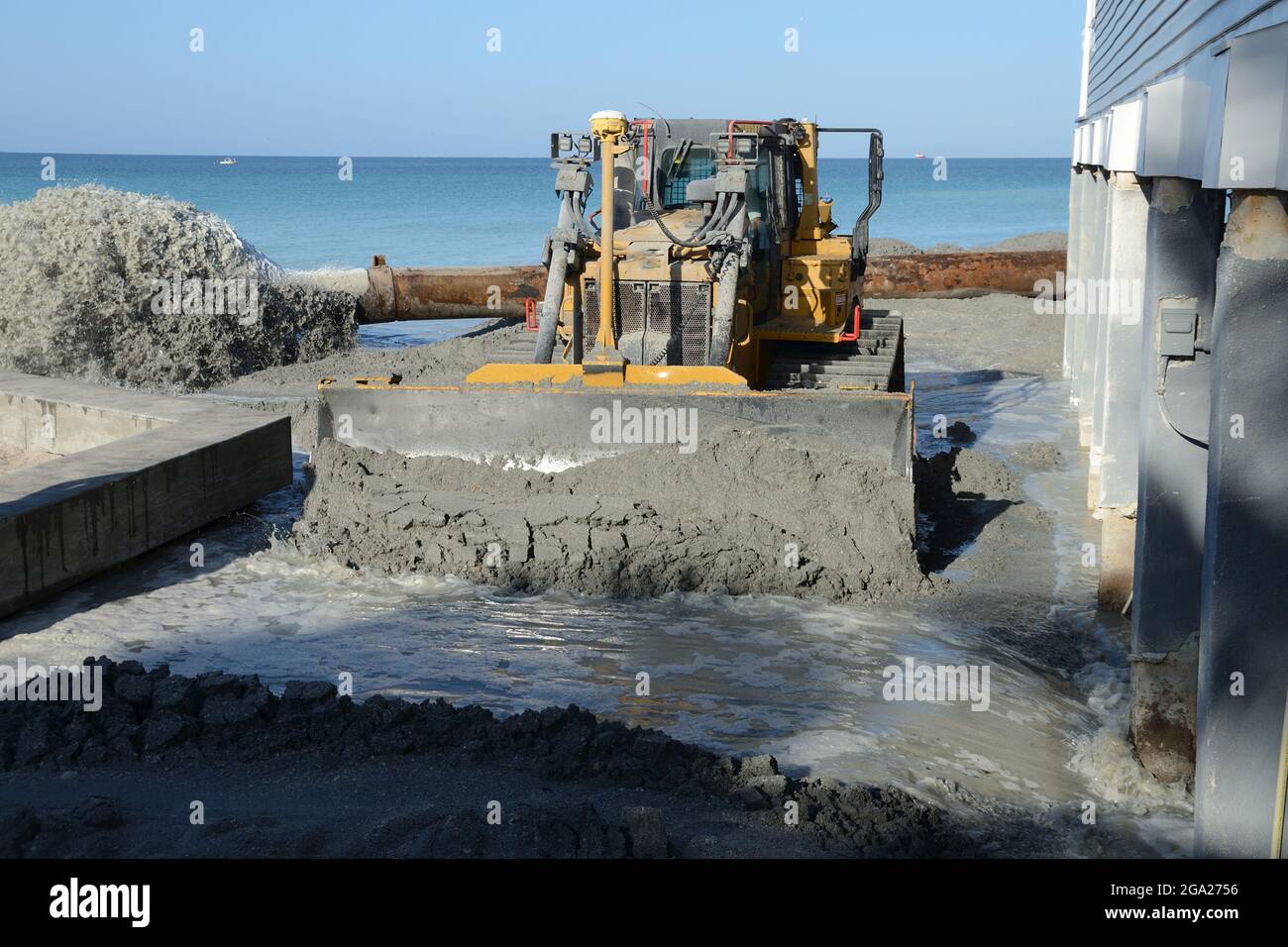 Bulldozer verteilt Sand und Wasser (Gülle) für Beach Renourishment Stockfoto