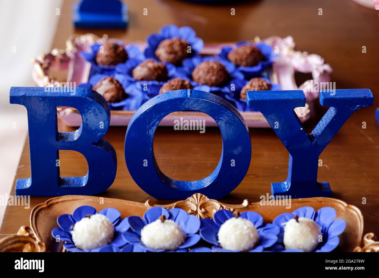 Große blaue Buchstaben JUNGE und Süßigkeiten auf dem Tisch bei der Offenbarung Tee-Party - Baby Geschlecht offenbaren Party-Konzept Stockfoto