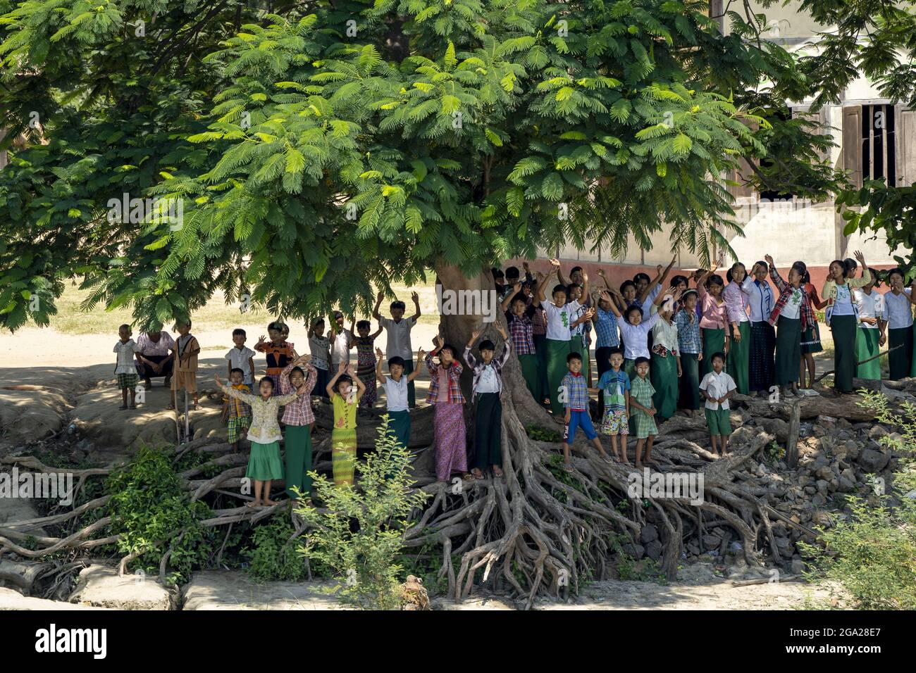 Schulkinder, die am Flussufer in einem ländlichen Dorf entlang des Ayeyarwady-Irrawaddy-Flusses, Myanmar-Burma- Stockfoto