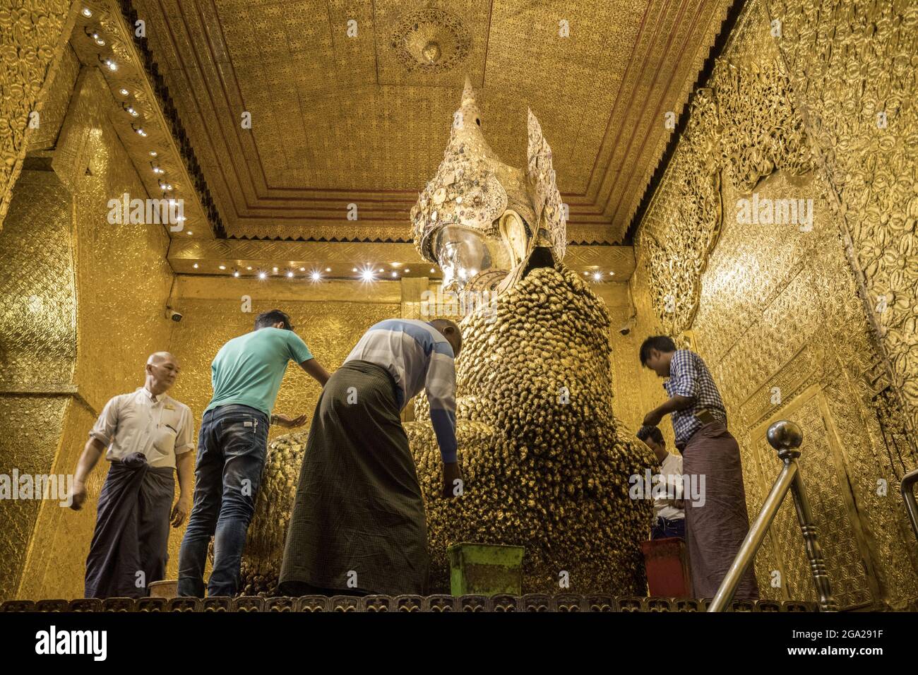 Pilger legen Blattgold auf das Maha Muni Buddha Bild, in der Großen Salbei Pagode, Mandalays wichtigster religiöser Struktur, Myanmar-Burma Stockfoto