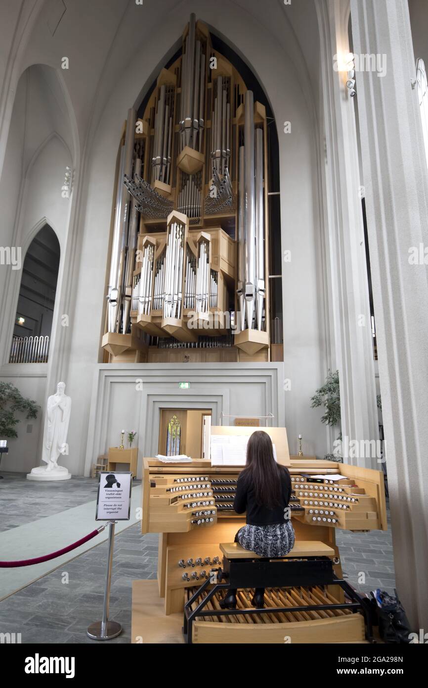Organist spielt die Orgel in der Hallgrimskirkja, der lutherischen Kathedrale in Reykjavik, Island; Reykjavik, Hauptstadtregion, Island Stockfoto