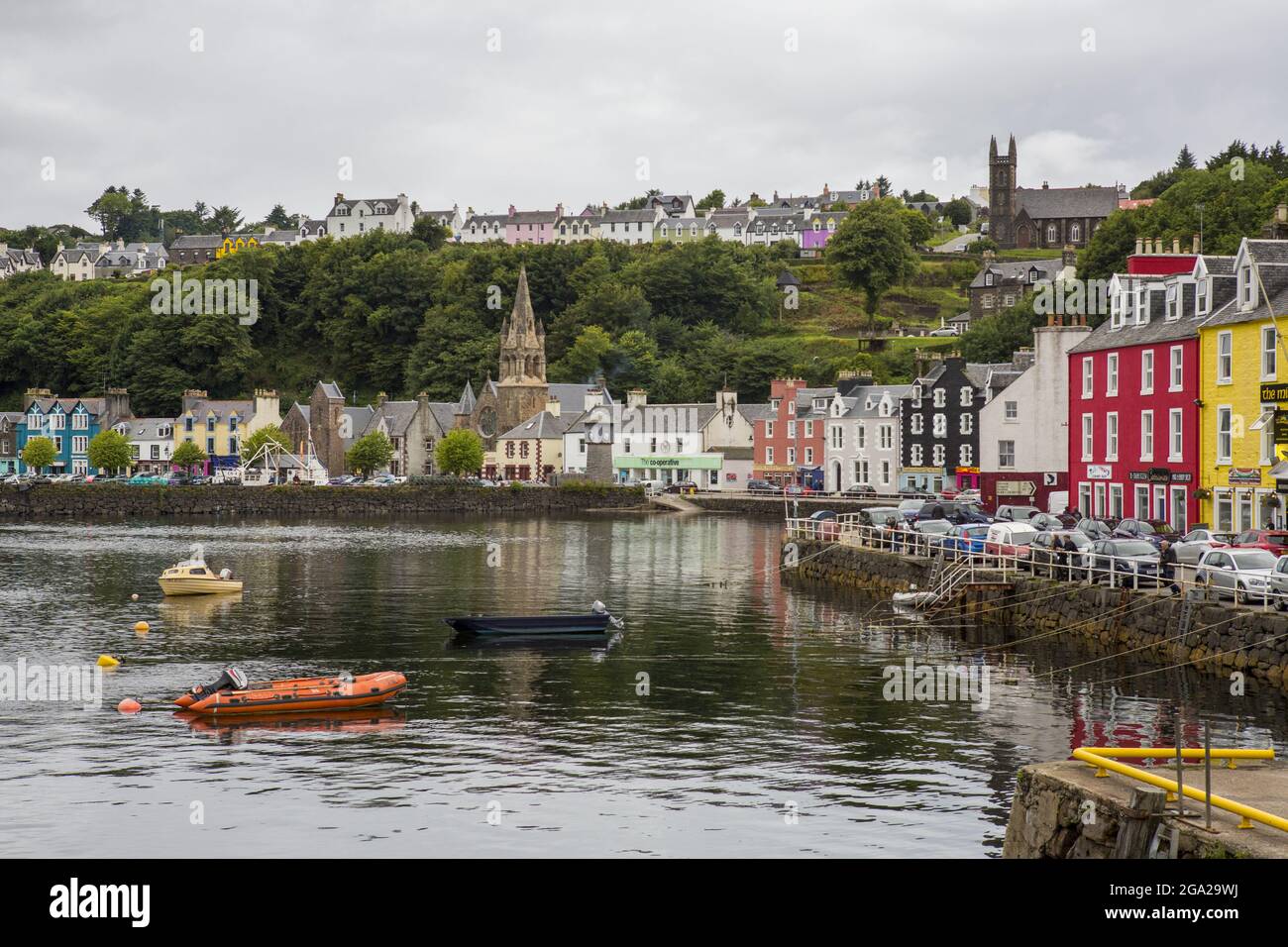 Mehrere kleine Boote schweben im Hafen des farbenfrohen Dorfes Tobermory, das sich auf der Isle of Mull, Schottland, befindet. Stockfoto