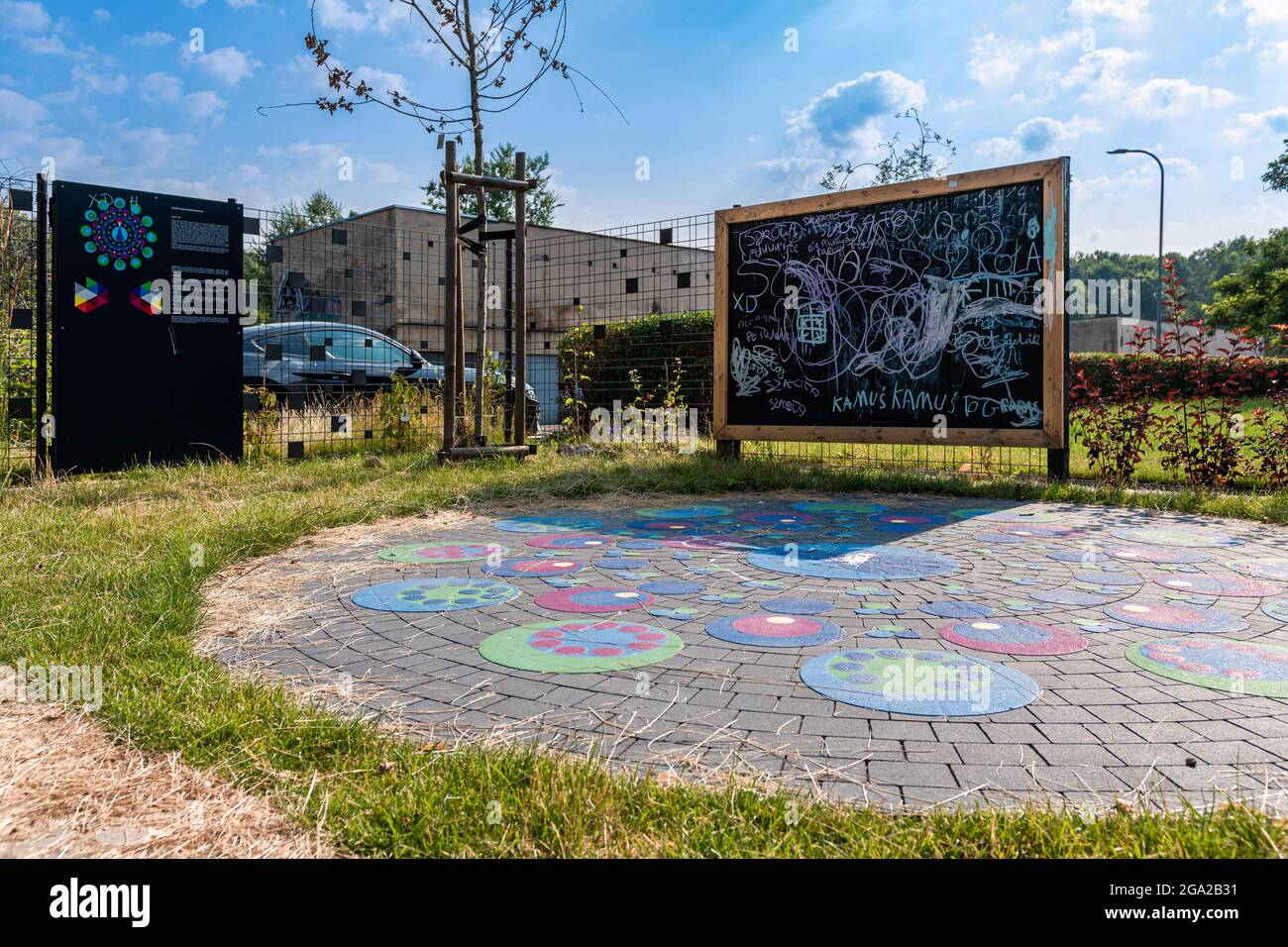 Große, hölzerne Kreidetafel und bunte Straßenspiel im Freien Spielplatz platziert. Sonniger Tag, Bäume im Hintergrund. Stockfoto