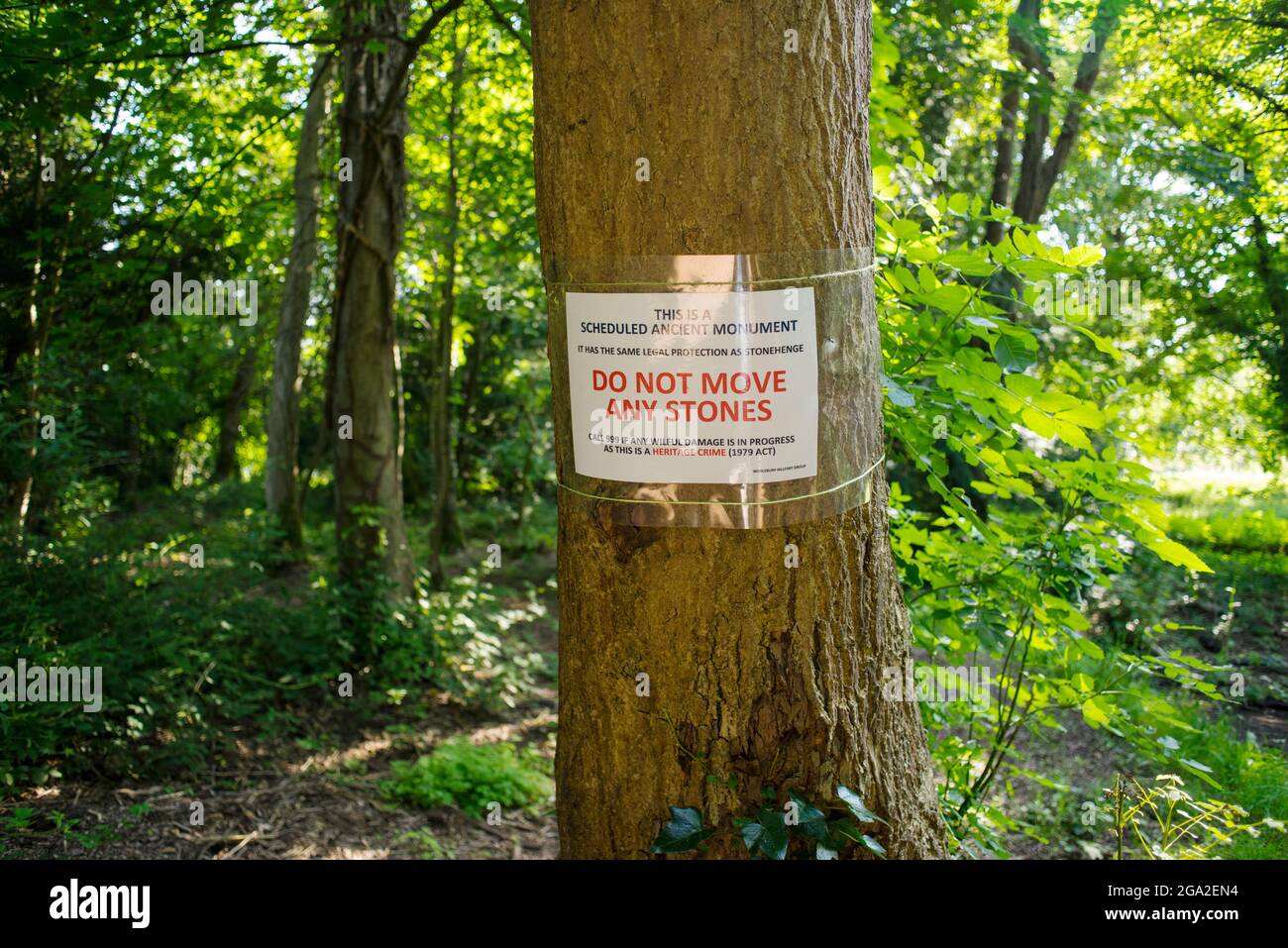 Ein Schild, das vor sich bewegenden Steinen am Standort des eisenzeitlichen Forts in Worlebury in North Somerset warnt, das ein antikes Denkmal ist. Stockfoto