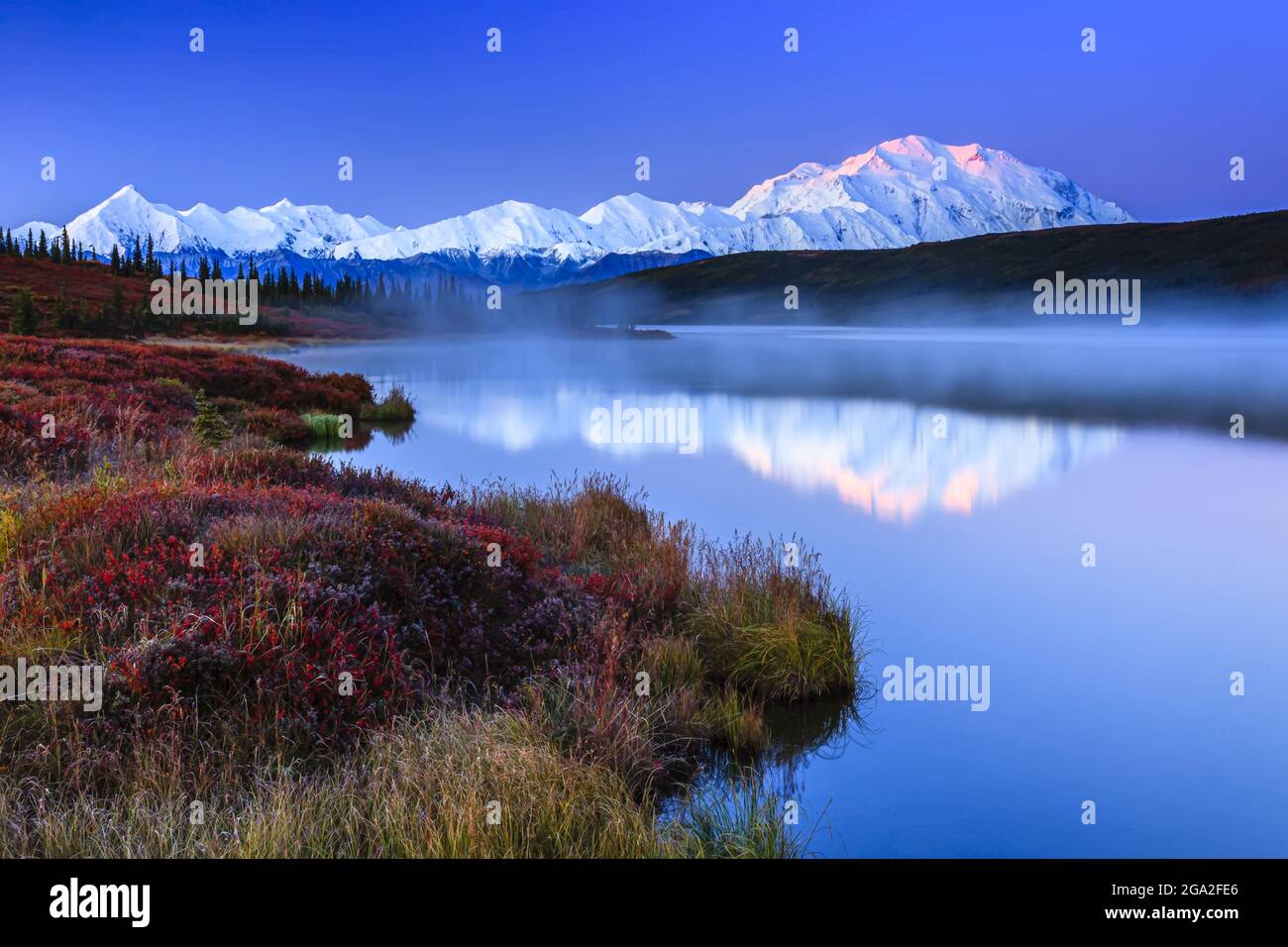 Spiegelung der Alaska Range Berge im ruhigen Wasser von Wonder Lake bei Sonnenaufgang im Denali National Park und Preserve Stockfoto