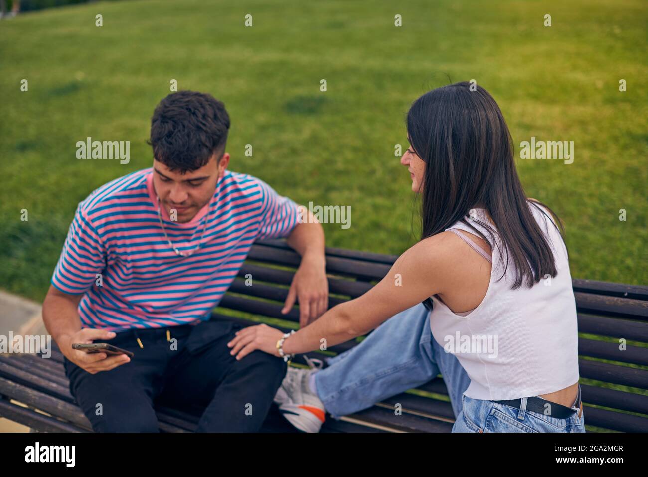 Junges Paar im Park mit Technologie Stockfoto