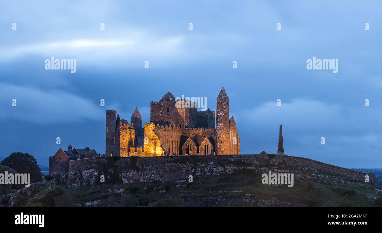 Der alte Rock of Cashel, der in der Abenddämmerung beleuchtet wird; Cashel, County Tipperary, Irland Stockfoto