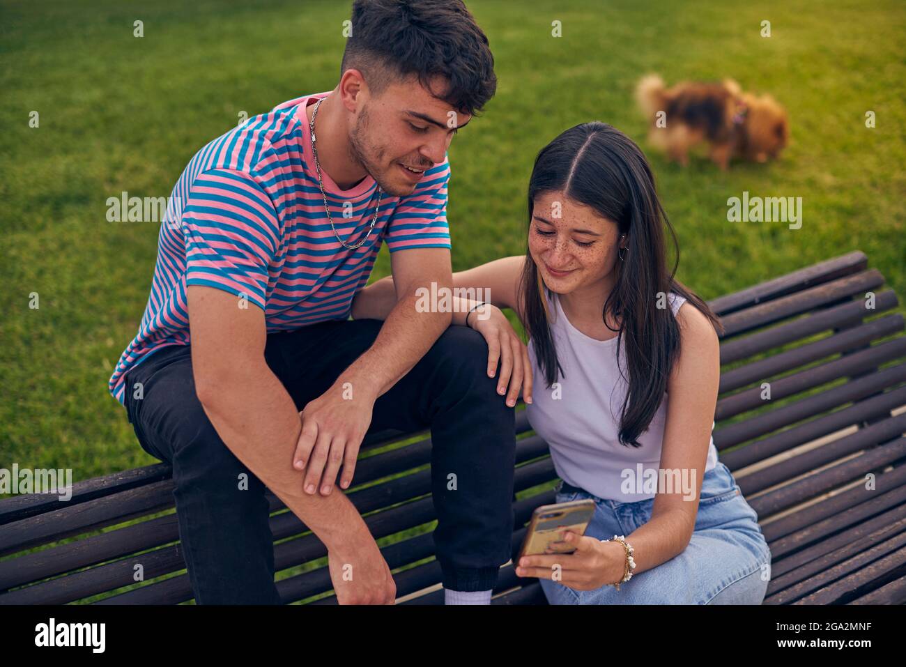 Junges Paar im Park mit Technologie Stockfoto