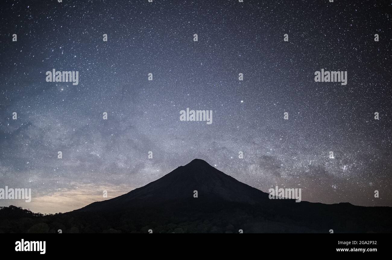 Die Milchstraße erhebt sich über einer dramatischen Silhouette des Arenal Vulkans, einem aktiven Stratovulkan; Alajuela Province, Costa Rica Stockfoto