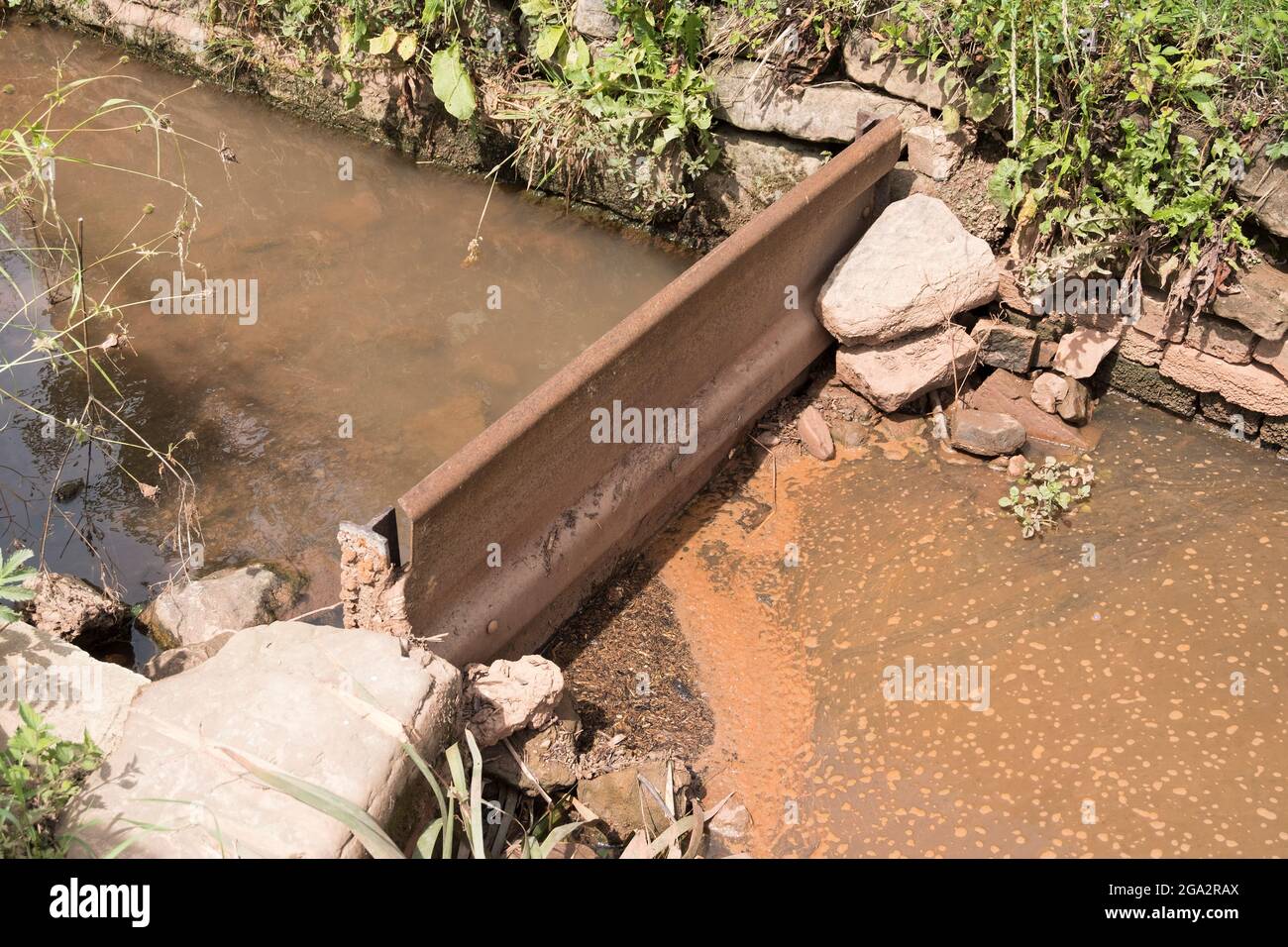 Kleiner Bach mit einer Hochwasserbarriere Stockfoto