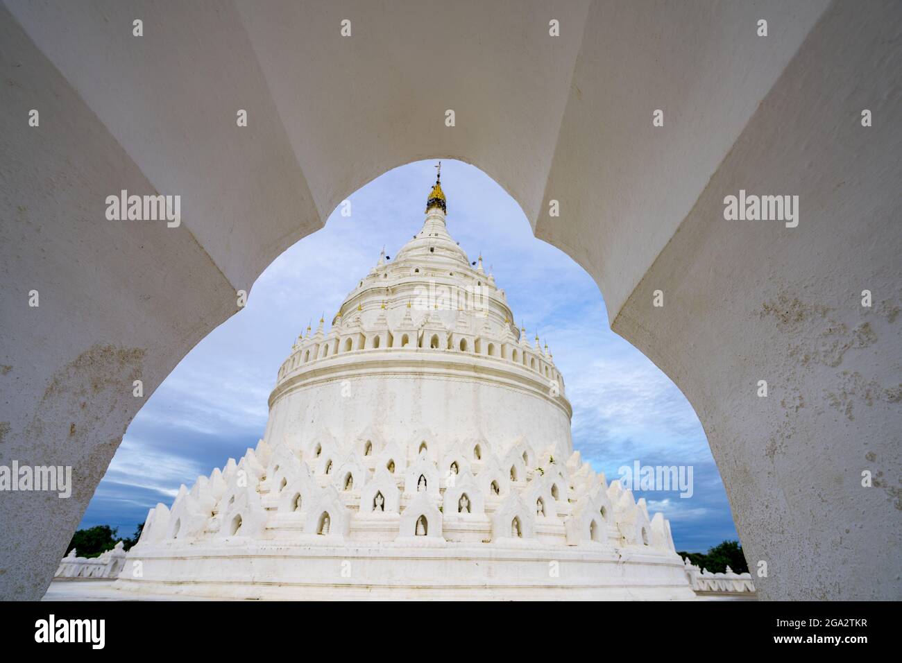 Blick durch den Eingangsbogen der Hsinphyume-Pagode (Mya Thein Tan Pagode), die weiß gestrichen ist und deren Design auf dem buddhistischen heiligen Berg basiert... Stockfoto