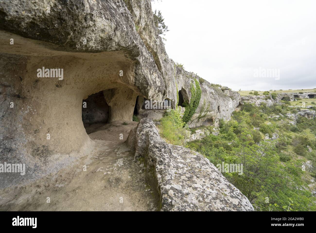 Blick auf die Felsenhöhlen entlang der Wanderwege durch den Fluss Gravina di Miera und den Park bei Miera; Miera, Basilicata, Italien Stockfoto