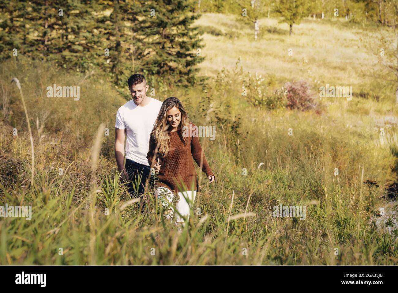 Ehemann und Ehefrau verbringen gemeinsam eine gute Zeit im Freien in der Nähe eines Baches in einem Stadtpark; Edmonton, Alberta, Kanada Stockfoto
