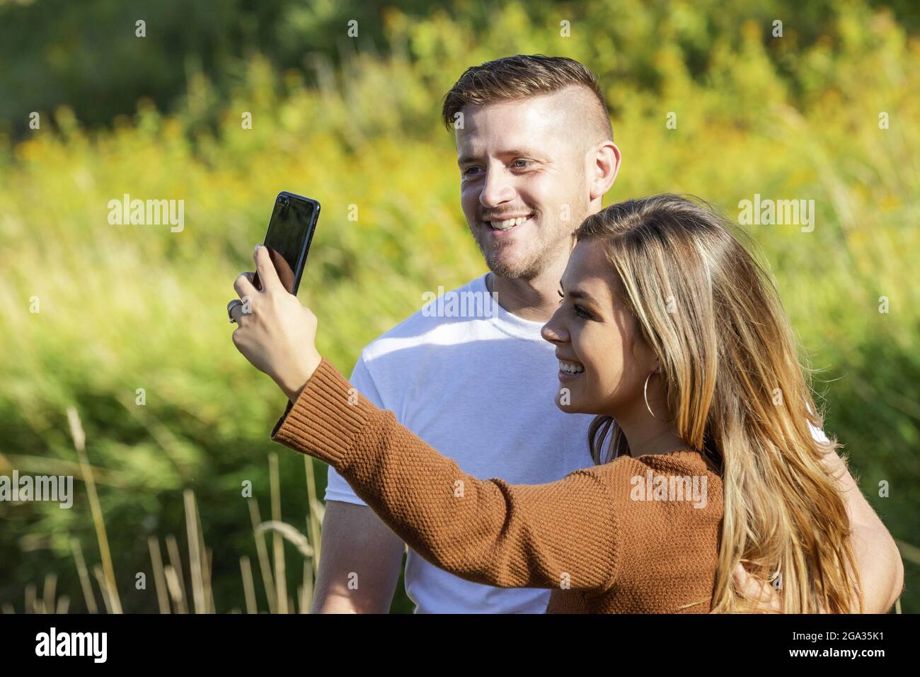 Ehemann und Ehefrau verbringen viel Zeit zusammen im Freien und machen ein Selbstporträt in einem Stadtpark; Edmonton, Alberta, Kanada Stockfoto