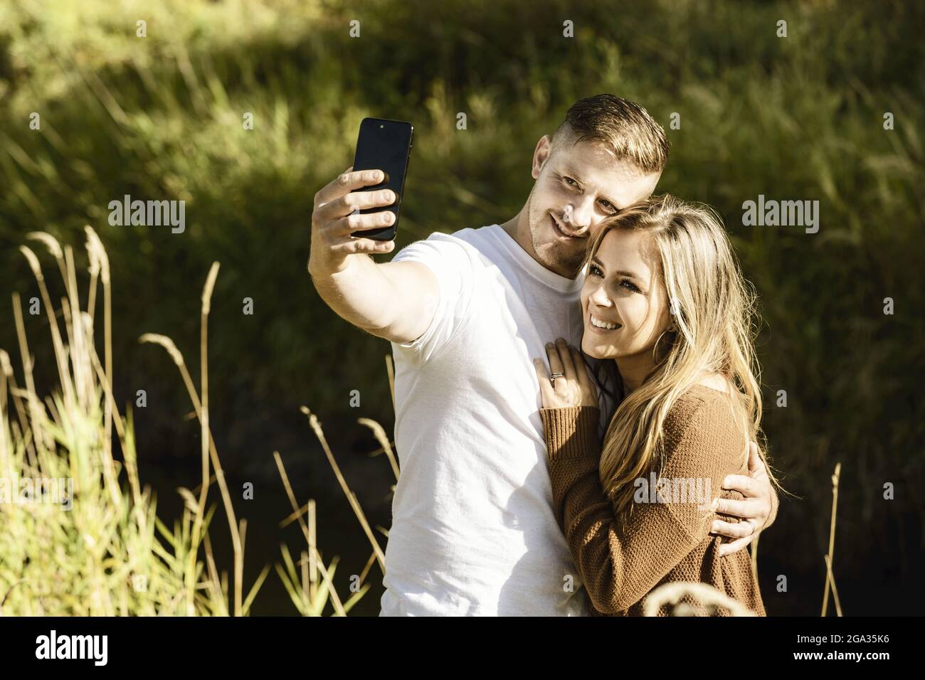 Ehemann und Ehefrau verbringen viel Zeit zusammen im Freien und machen ein Selbstporträt in einem Stadtpark; Edmonton, Alberta, Kanada Stockfoto