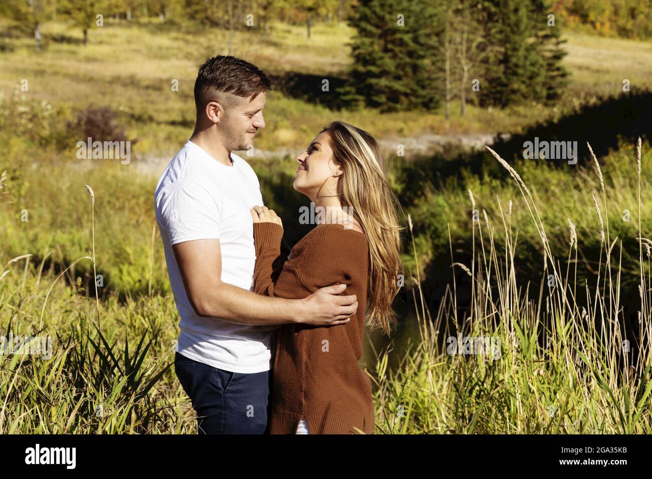 Ehemann und Ehefrau verbringen gemeinsam eine gute Zeit im Freien in der Nähe eines Baches in einem Stadtpark; Edmonton, Alberta, Kanada Stockfoto