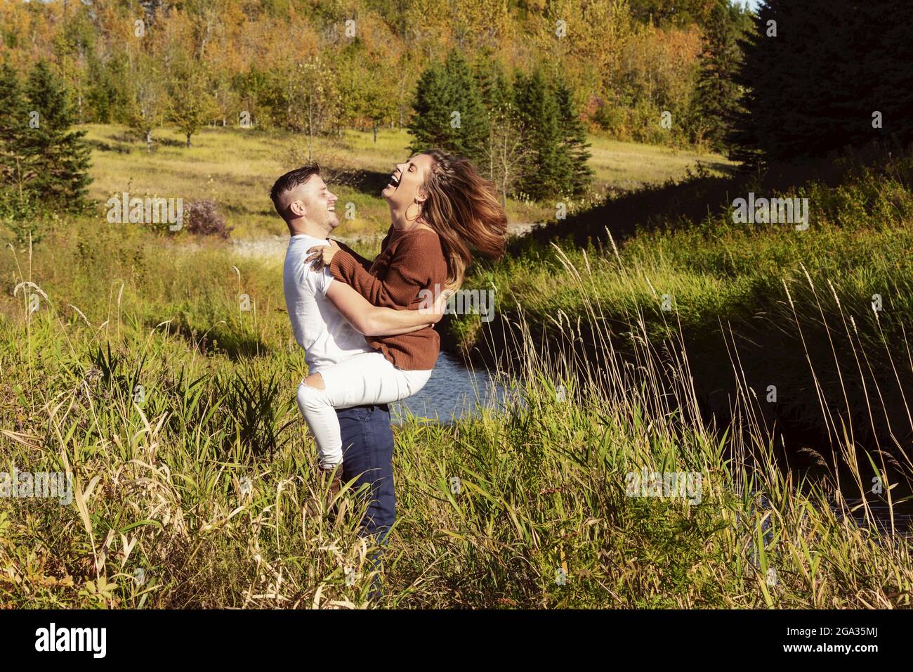 Ehemann und Ehefrau verbringen gemeinsam eine gute Zeit im Freien in der Nähe eines Baches in einem Stadtpark; Edmonton, Alberta, Kanada Stockfoto