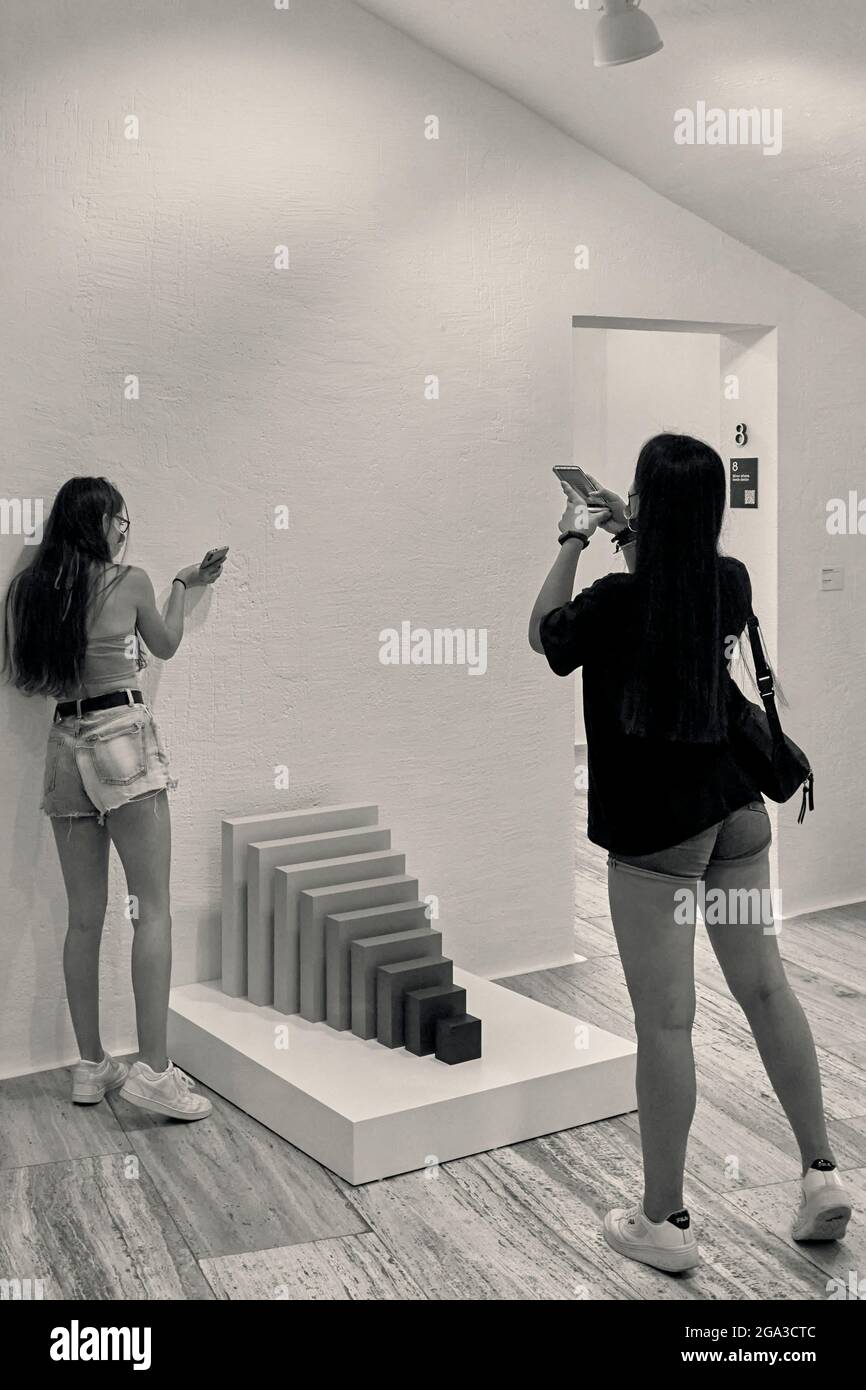 Zwei junge Mädchen, die im spanischen Museum für abstrakte Kunst der Stiftung Juan March in Cuenca mit einem Handy ein Foto einer Skulptur machen, Spanien. Stockfoto