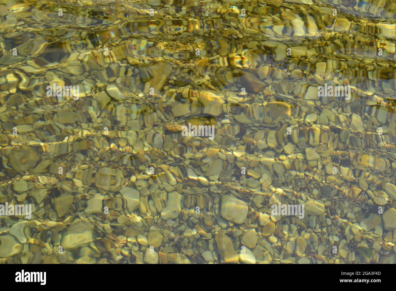 Transparentes Wasser mit runden Steinen auf einem Flussbett, das die Bewegung des Wassers darstellt. Capitolio, MG, Brasilien Stockfoto