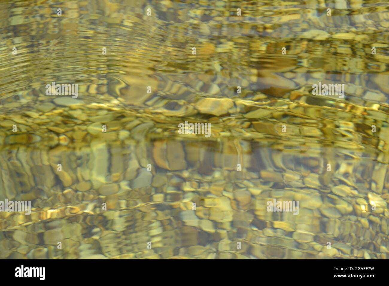 Transparentes Wasser mit runden Steinen auf einem Flussbett, das die Bewegung des Wassers darstellt. Capitolio, MG, Brasilien Stockfoto