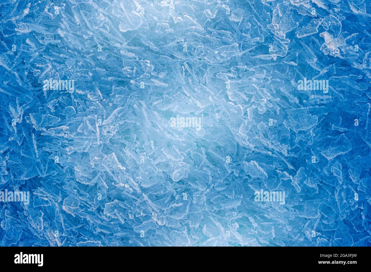 Kühles blaues Winterthema Hintergrund von gefrorenen Eiskristallen mit moderner Beleuchtung. Stockfoto