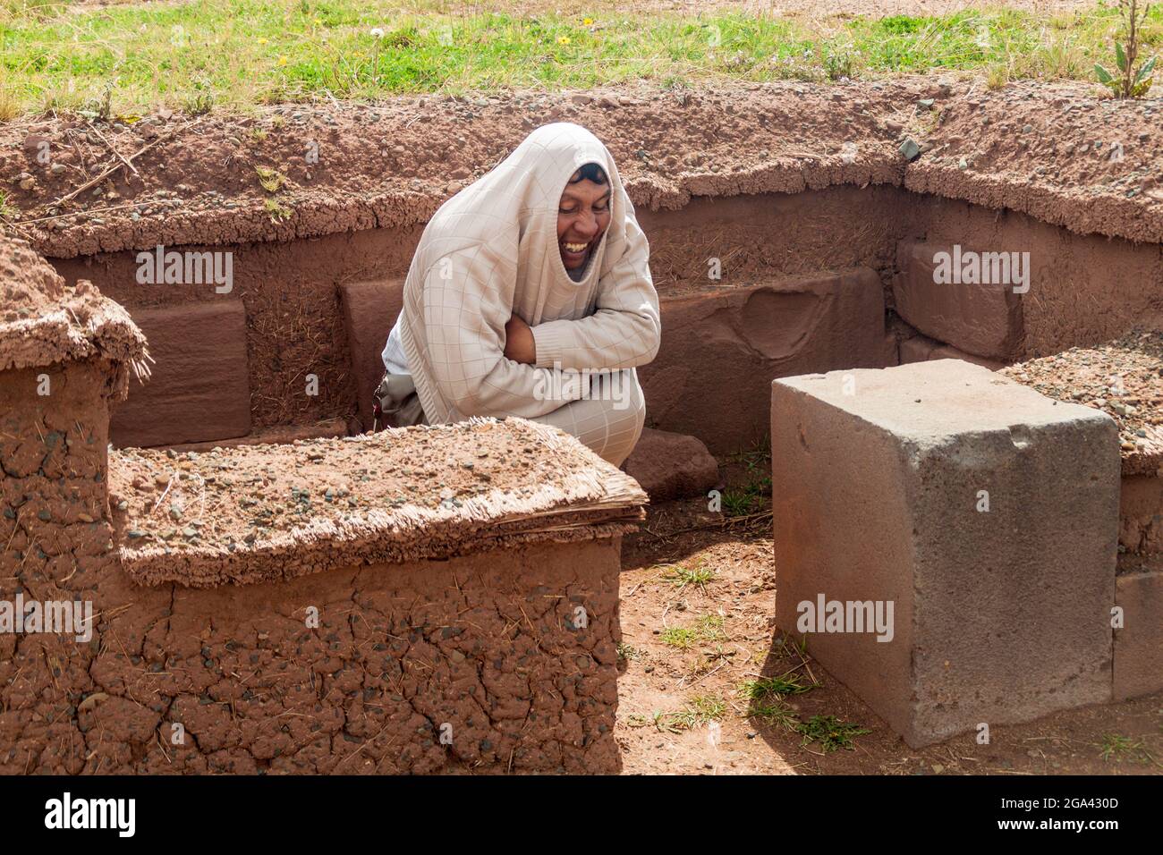 TIWANAKU, BOLIVIEN - 24. APRIL 2015: Reiseführer zeigt die Lage der Leichen in einem Grab, Ruinen von Tiwanaku, Region Titicaca, Bolivien. Stockfoto