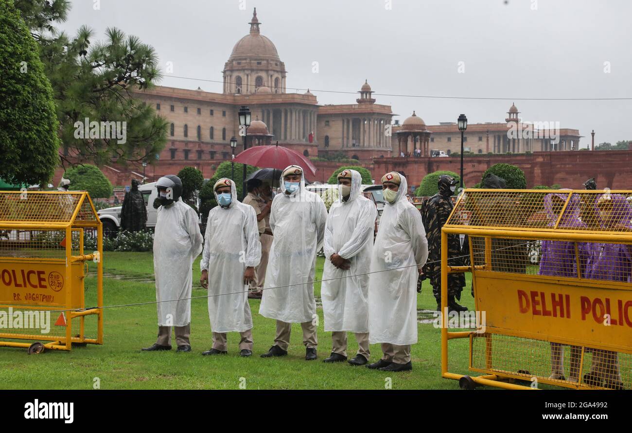 Neu-Delhi, Indien. Juli 2021. Die Polizei von Delhi trägt Gesichtsmasken und Regenmäntel, während sie während des Monsunregens in Vijay Chowk im Dienst ist. Starke Regenfälle haben zur Wasserabholzungen auf der Straße in der Landeshauptstadt geführt. Kredit: SOPA Images Limited/Alamy Live Nachrichten Stockfoto