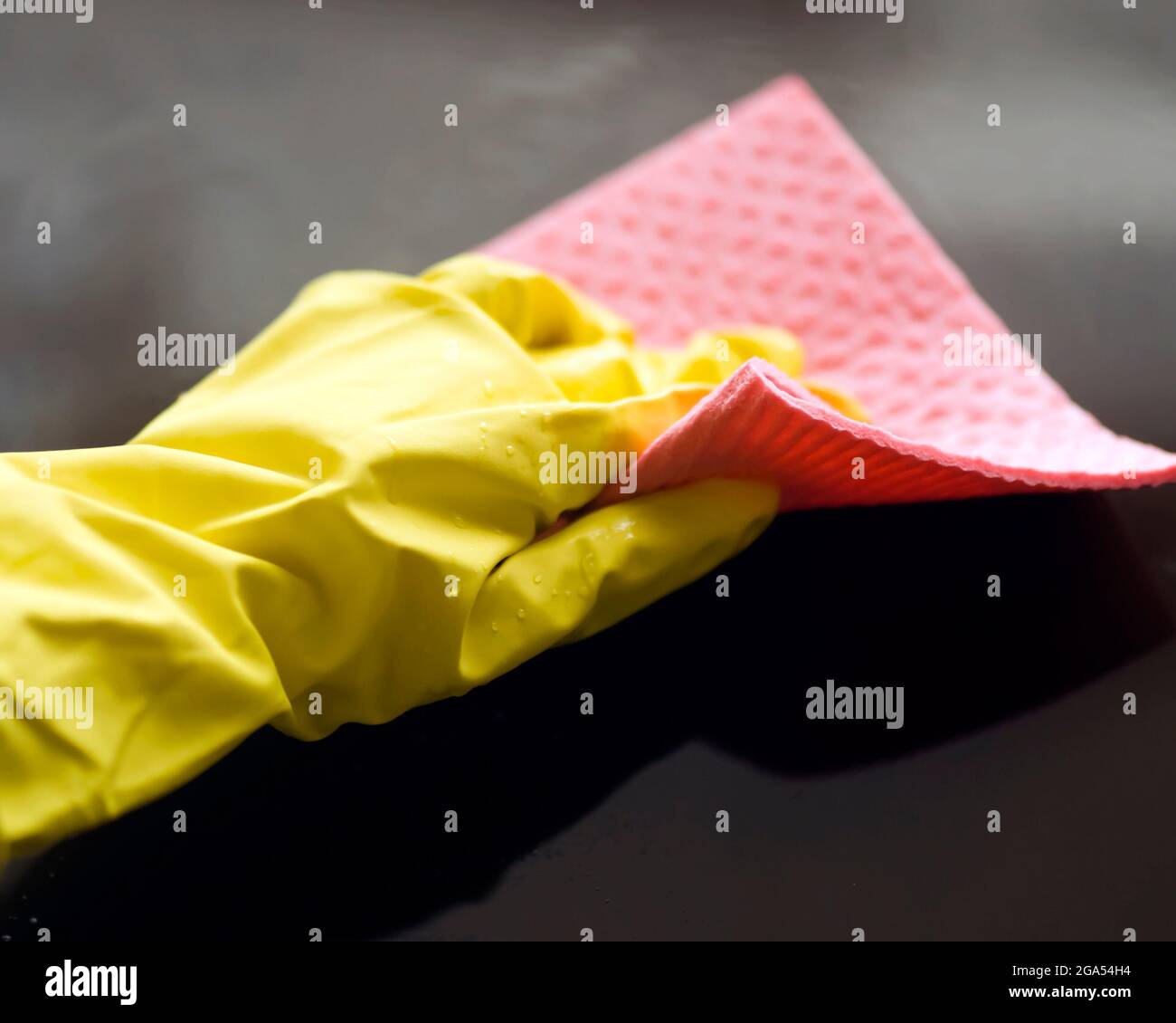 Eine Frau in gelben Gummihandschuhen macht Hausarbeit Stockfoto