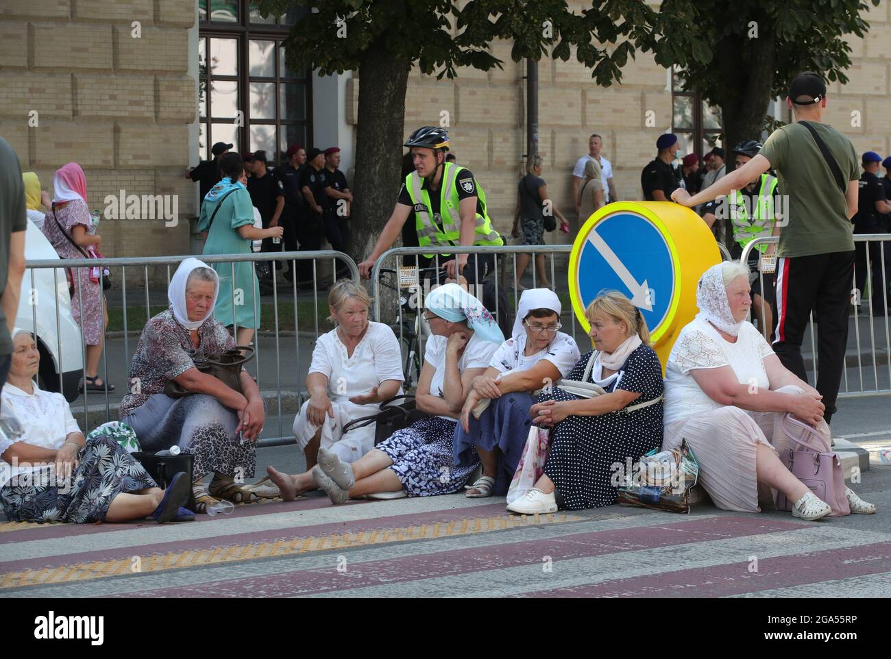 Nicht exklusiv: KIEW, UKRAINE - 27. JULI 2021 - während der Kreuzprozession vom Wolodymyrska-Hügel (St. Wolodymyr-Hügel) nach sitzen eifrige Anhänger auf dem Boden Stockfoto