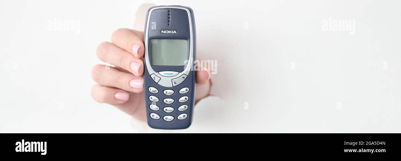 Weibliche Hand halten Taste Telefon Nokia 3310 Stockfoto