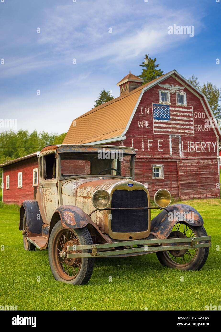 Altes Auto vor der Scheune „in god we Trust“ in Latah, einer Stadt im Spokane County, Washington, USA Stockfoto