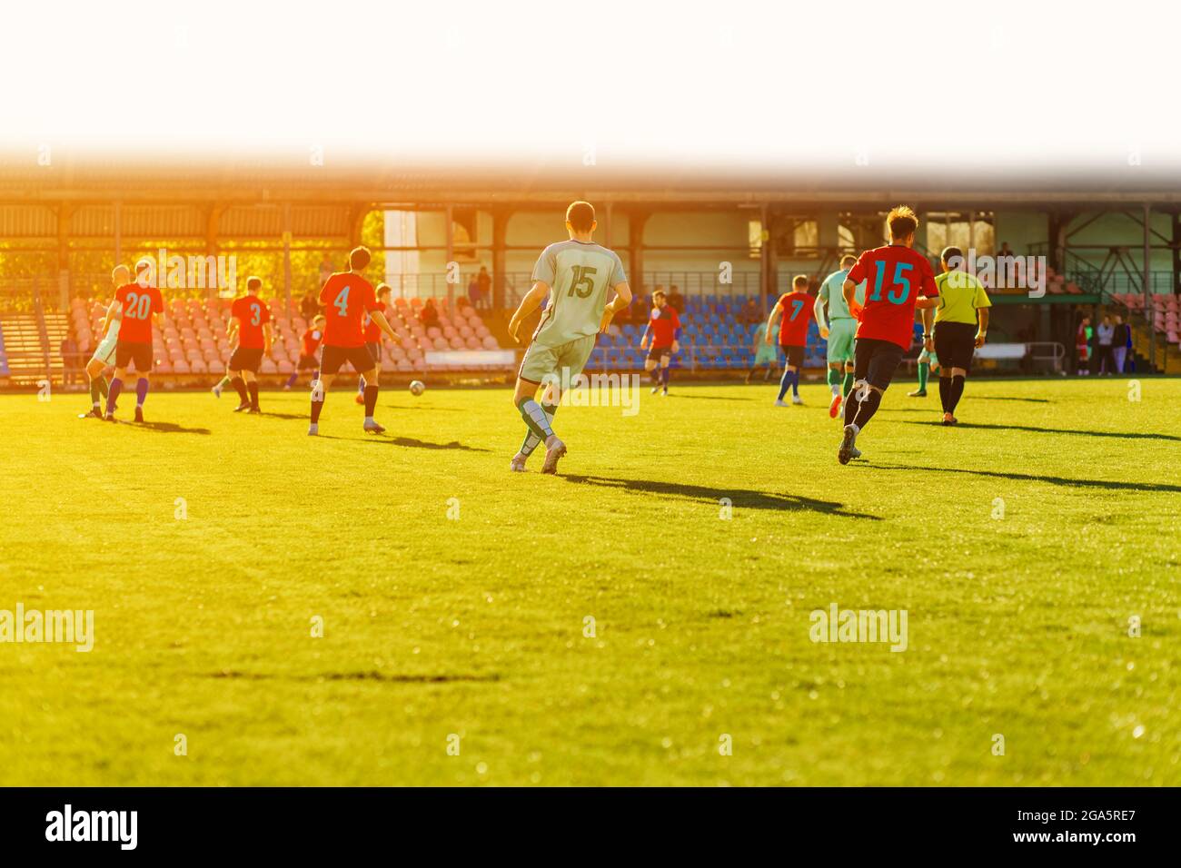 Fußballspieler spielt ein dynamisches Spiel in einem professionellen Stadion, eine Gruppe von jungen Fußballern auf einem offenen Platz spielen. Profi-Sportkonzept, Fußball Stockfoto