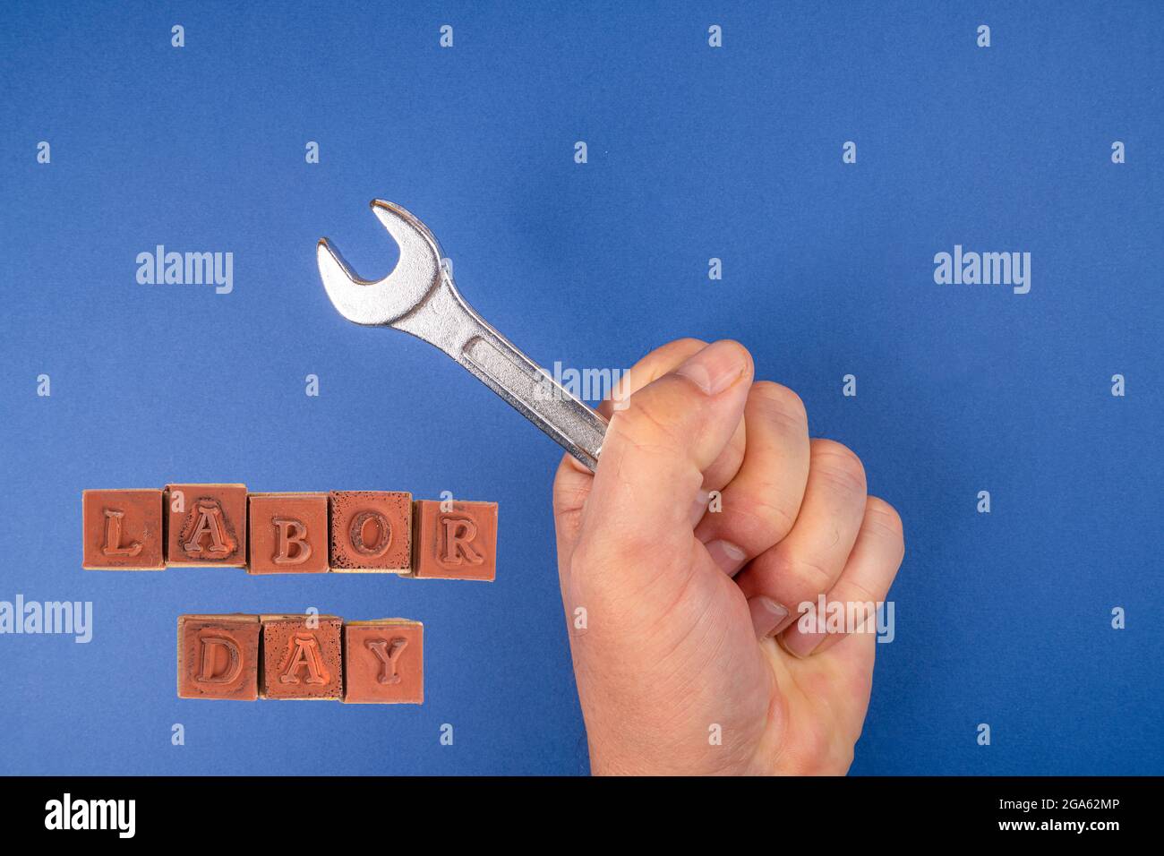 Werkzeug in der Hand mit einem Labor Day-Zitat arbeiten Stockfoto
