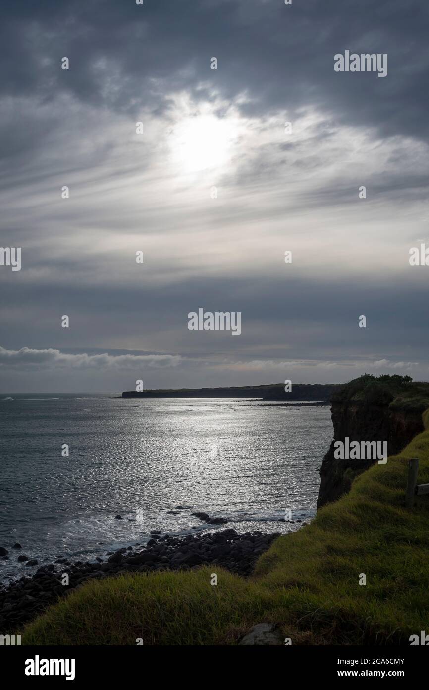 Sonne scheint durch Wolken auf Meer und Küste, Middleton Bay, Opunaki, Taranaki, Nordinsel, Neuseeland Stockfoto