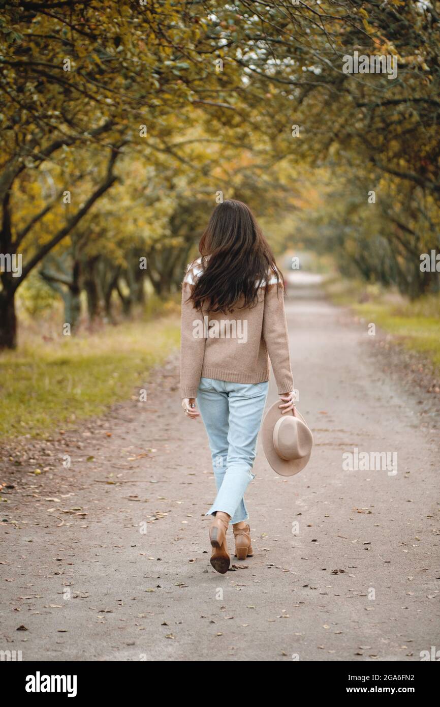 Rückansicht einer Wanderfrau im Herbstpark. Stockfoto
