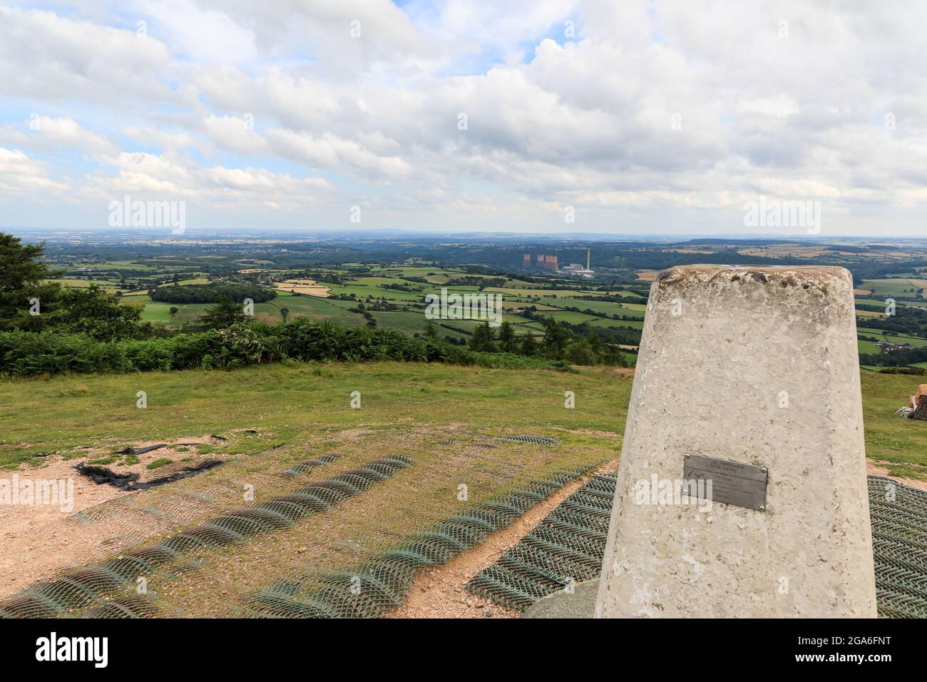 Ein OS trig Point oder Ordnance Survey Triangulationspunkt oder eine Säule auf dem Wrekin, der über der Shropshire Plain, Shropshire, England, Großbritannien, steigt Stockfoto