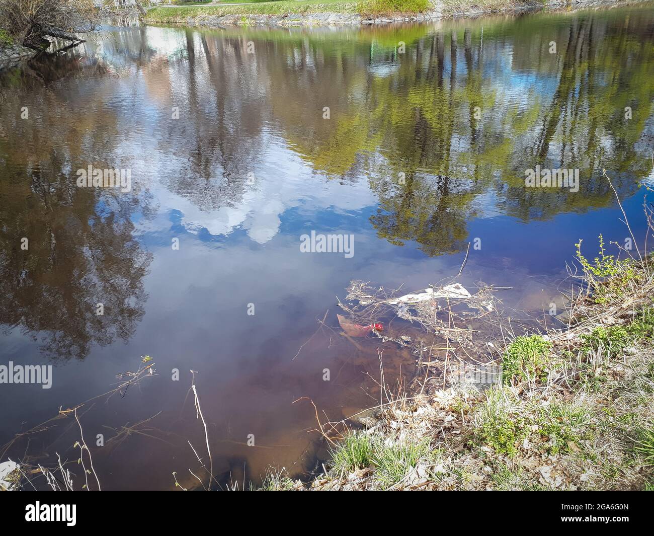 Hochwinkelaufnahme des Flussufers mit Müll in Orebro Stockfoto