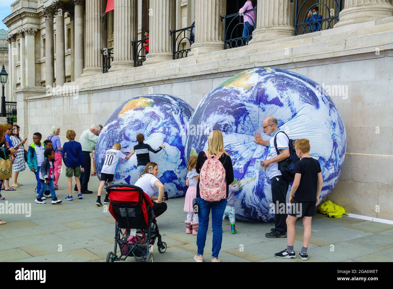 London, Großbritannien, 29. Juli 2021. Earth Overshoot Day Demonstration von Population Matters Charity auf dem Trafalgar Square in London. Sensibilisierung für die Übernutzung der natürlichen Ressourcen der Erde durch eine ständig wachsende Bevölkerung und die Auswirkungen, die dies auf den Klimawandel hat. Viele Familien, die in den Schulferien die aufblasbaren Erden der Wohltätigkeitsorganisation nutzen. Kredit: Bradley Taylor / Alamy Live Nachrichten Stockfoto