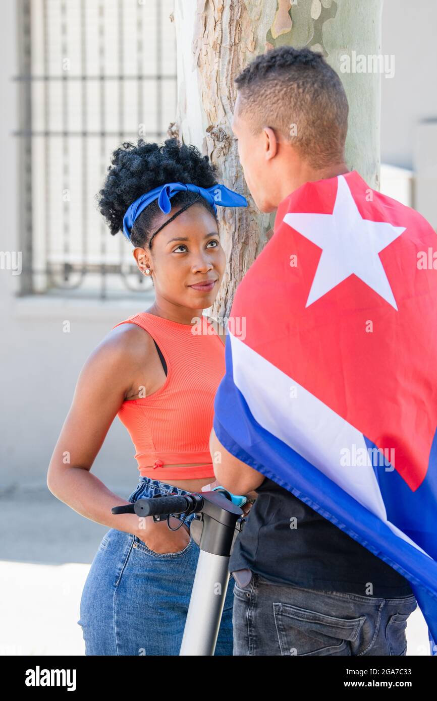 Latina-Frau schaut liebevoll auf einen Latino-Mann mit kubanischer Flagge Stockfoto
