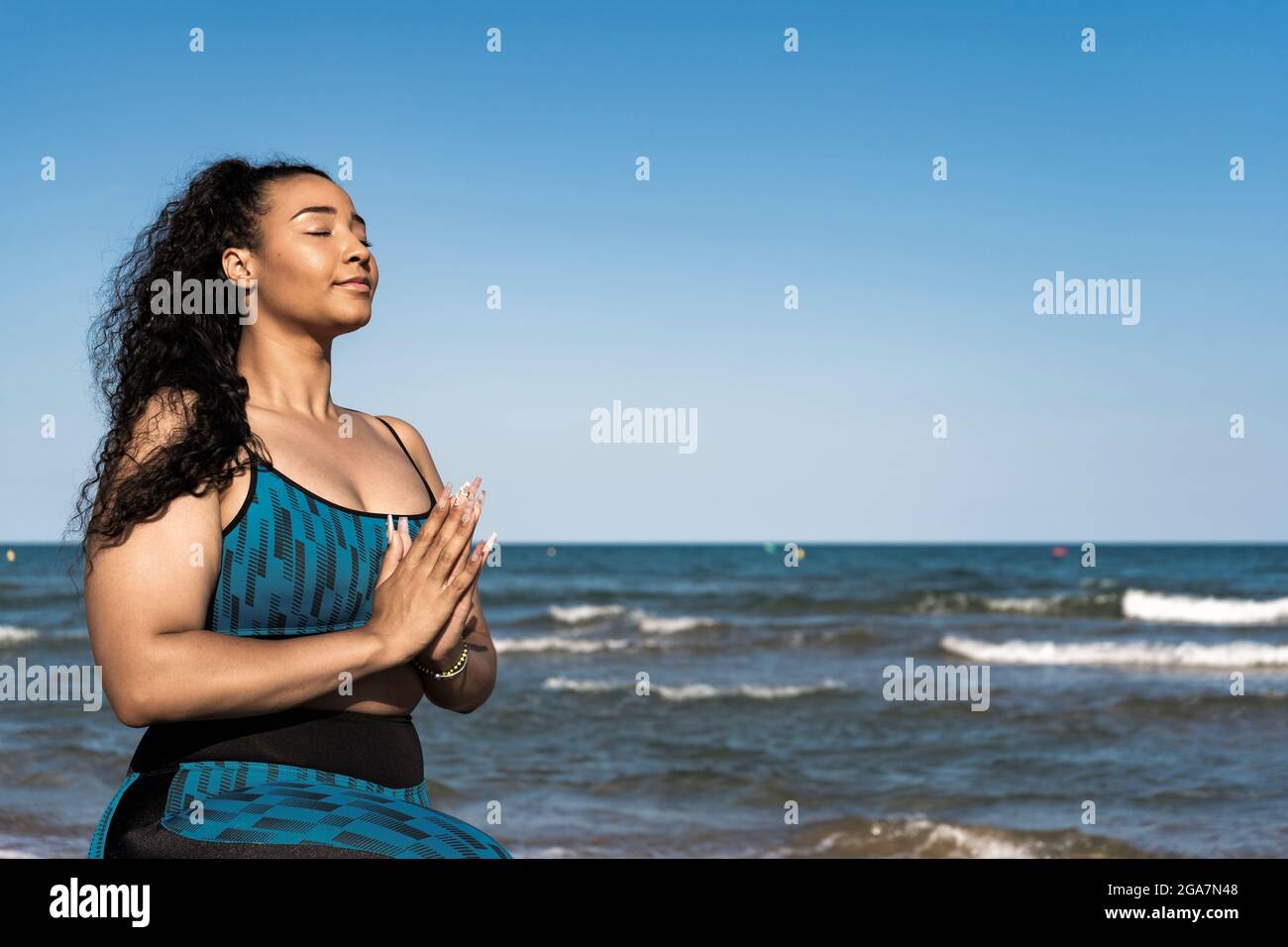 Schöne Frau, die Yoga praktiziert, mit Namen am Strand Stockfoto