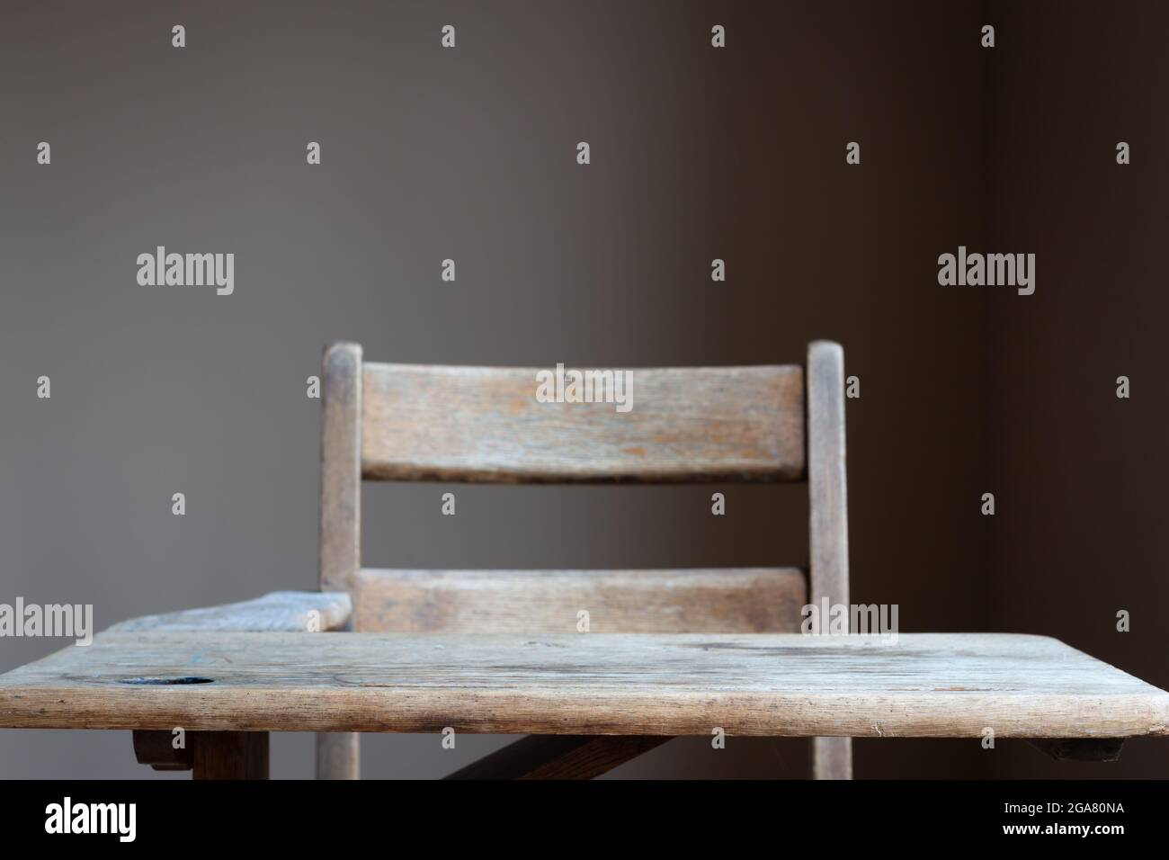 Isolierter Schulschreibtisch aus Vintage-Holz mit Fokus auf der Vorderkante des Schreibtisches mit neutralem Hintergrund und Platz für Kopien Stockfoto