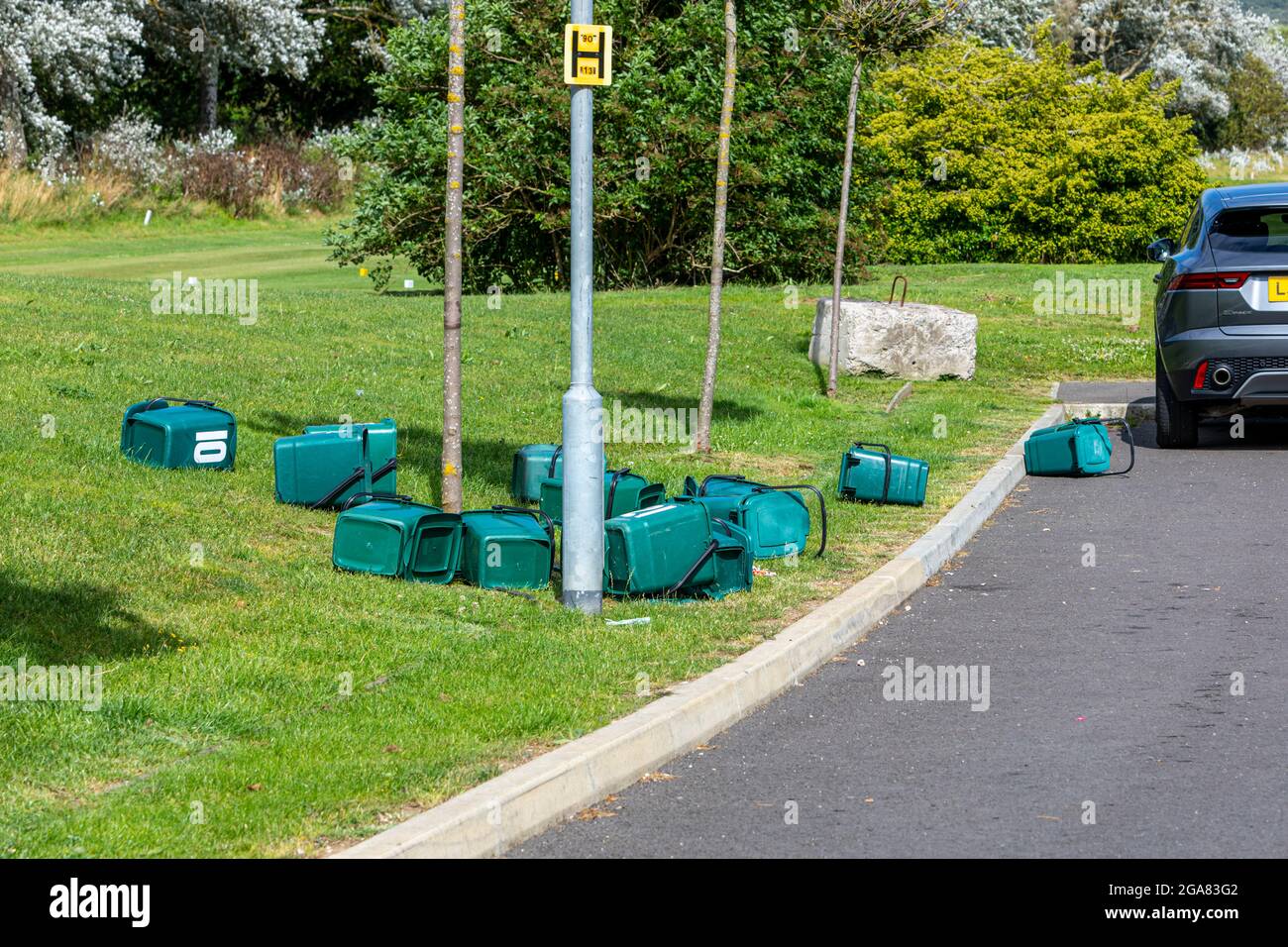 Lebensmittelbehälter, die über Gras und eine Straße verteilt sind Stockfoto