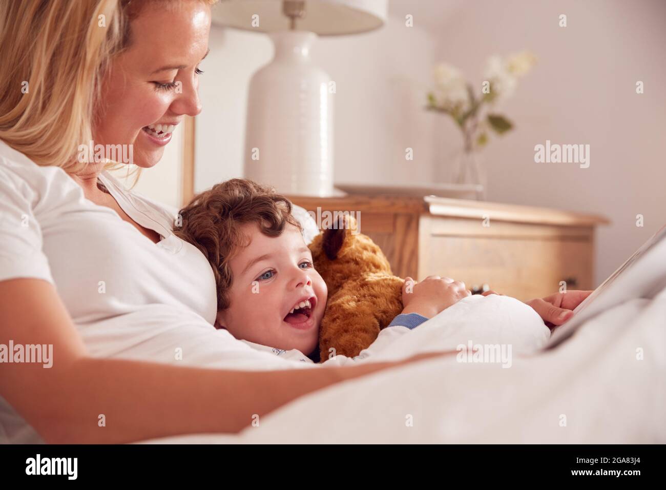 Mutter Im Schlafzimmer Blick Auf Bilderbuch Mit Jungen Sohn Trägt Pyjama Kuscheltier Weichen Spielzeug Stockfoto