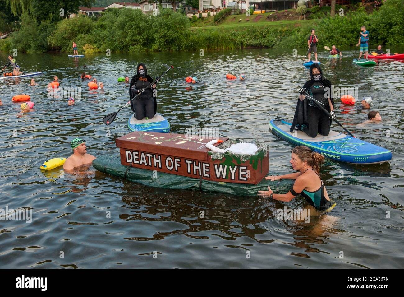 Die Spezialistin für Wildschwimmen und Autorin Angela Jones alias „The Wild Woman of the Wye“ führt ein 1-km-Bad im Monmouth-Abschnitt des Wye-Flusses, um auf den katastrophalen ökologischen Zustand des Flusses Wye und seine anhaltende Verschlechterung aufmerksam zu machen. Ein Nachbau-Sarg auf einem Paddelbrett wurde in den Fluss gesenkt und von Angela geschleppt, um den Tod des Wye darzustellen. Ihr Schwimmen ist Teil der #SaveTheWye, einer Dachkampagne zur Unterstützung und zum Aufbau eines Netzwerks von Organisationen und Einzelpersonen, die sich für den Schutz und die Wiederherstellung der Gesundheit des Flusses Wye und seiner Nebenflüsse einsetzen, sowohl für die Tierwelt als auch für die Menschen Stockfoto