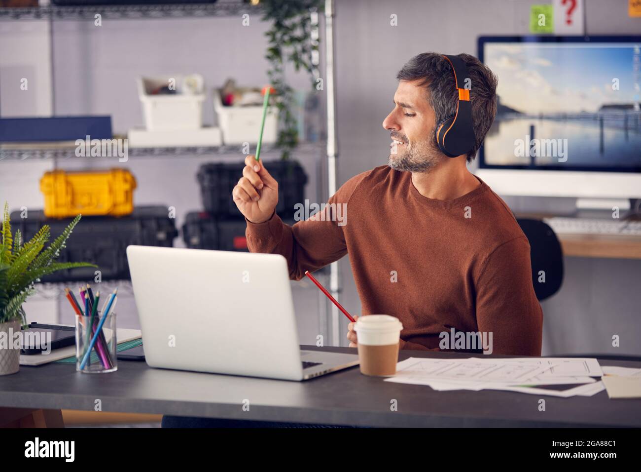 Werbung Für Männer Marketing Oder Kreatives Design Mit Kabellosen Kopfhörern Air Drumming Am Schreibtisch Stockfoto