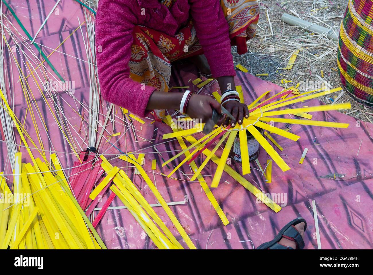 Indische Künstlerin weben Korbkorbhandarbeiten. Indische Handarbeiten sind berühmt für farbenfrohe und detailreiche Kunst. Ihre Hände im Rahmen. Kalkutta, Wes Stockfoto