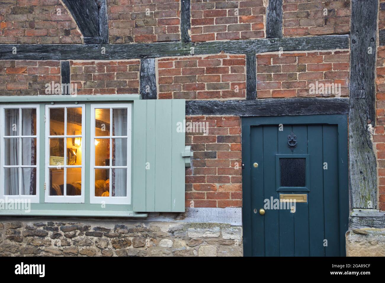Nahaufnahme einer Tür, Tür und eines Fensters mit Fensterverschluss im malerischen Dorf Lacock, Wiltshire, England, Großbritannien Stockfoto