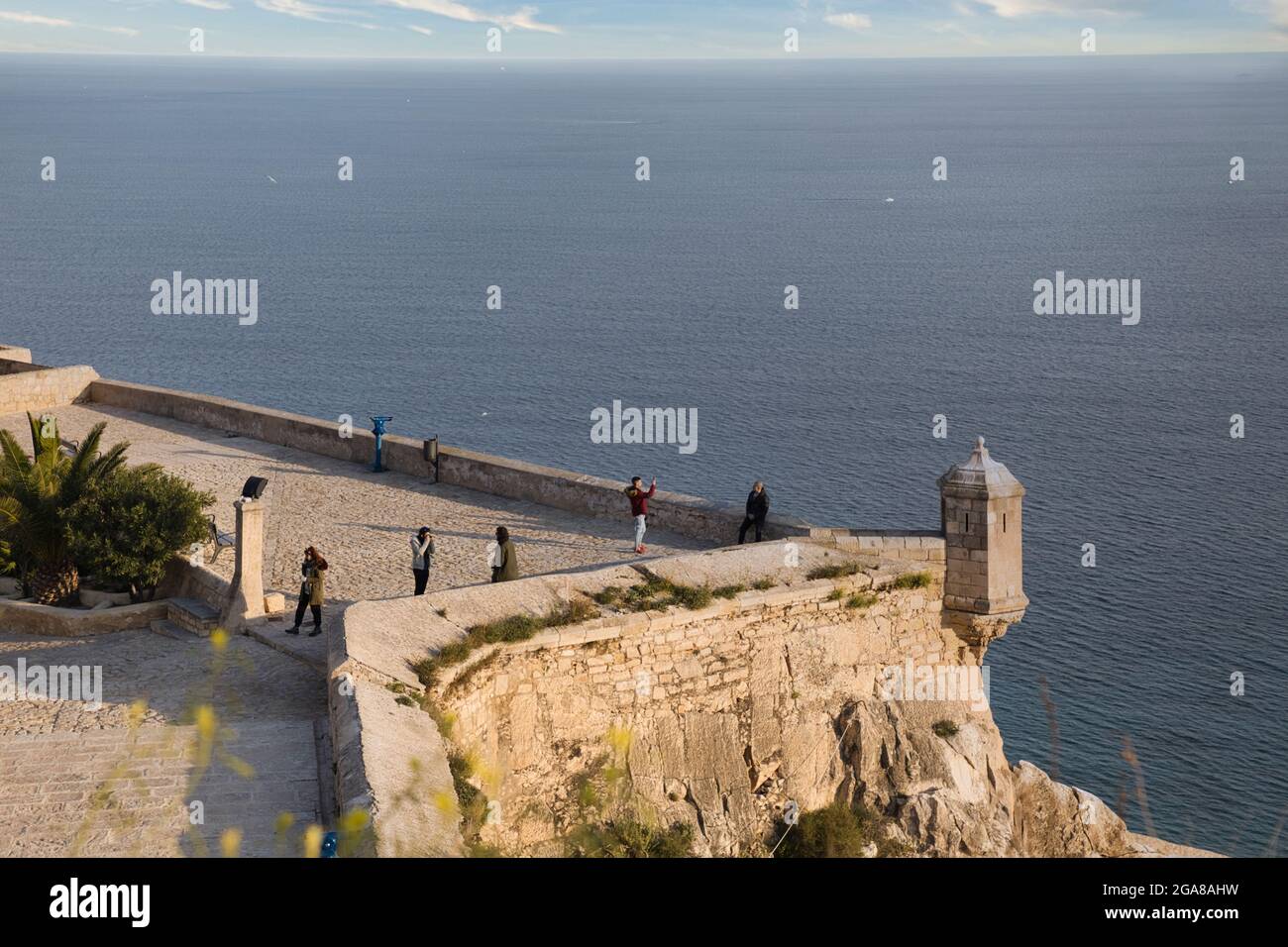 Ein Blick über die Burgmauern von Santa Barbara mit dem Mittelmeer dahinter, nach Alicante, Spanien. Menschen sehen Stockfoto