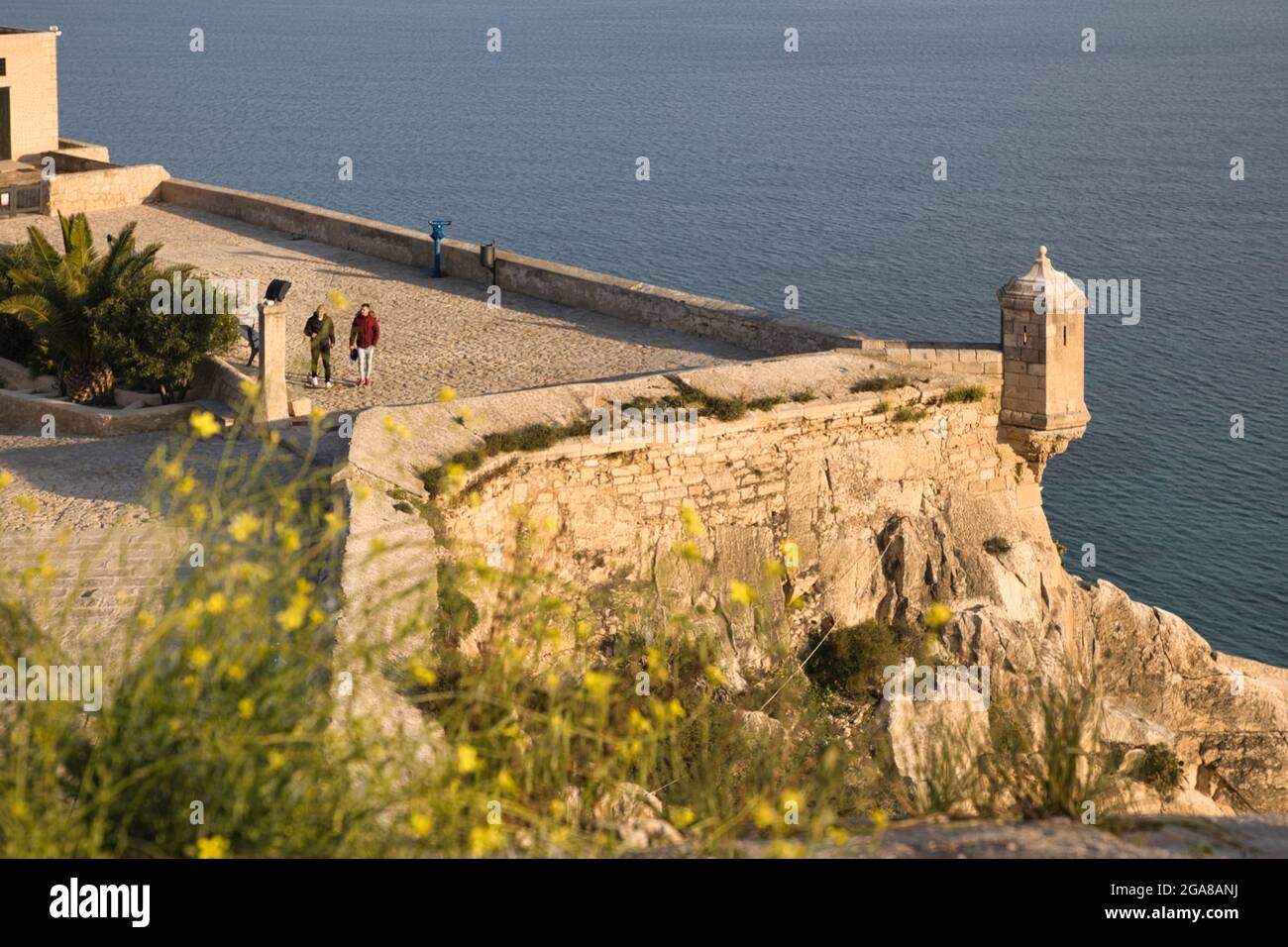 Ein Blick über die Burgmauern von Santa Barbara mit dem Mittelmeer dahinter, nach Alicante, Spanien. Menschen sehen Stockfoto