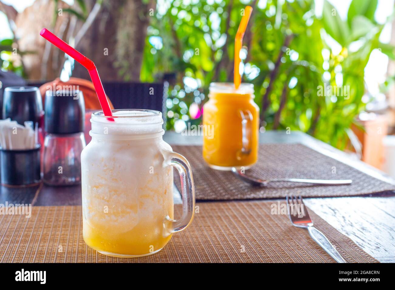 Kalter Smoothie aus Mango- und Ananasfrüchten auf dem Tisch in einem Café. Erholung in tropischen Ländern, gastronomischer Tourismus. Stockfoto